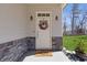 Elegant front door with wreath, stylish sconces, and stone accents at 1784 Treymire Ct, Stone Mountain, GA 30088