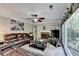 Comfortable living room with a leather sofa, fireplace, built-in shelving, and large windows at 3034 Brookgreen Trl, Lawrenceville, GA 30043