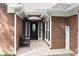 Covered entryway with brick facade, tiled patio, and a decorative door with a 'Welcome' sign at 11940 Wexford Club Dr, Roswell, GA 30075