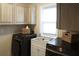 Functional laundry area includes modern washer and dryer units, a sink and cabinetry at 11940 Wexford Club Dr, Roswell, GA 30075