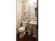 Charming powder room with decorative wallpaper, pedestal sink, and modern fixtures at 11940 Wexford Club Dr, Roswell, GA 30075