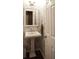 Powder room featuring a pedestal sink, decorative mirror, and stylish wallpaper at 11940 Wexford Club Dr, Roswell, GA 30075
