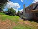 Backyard view with a spacious lawn, trees, brick house, and a wooden deck area at 1255 Home Place Dr, Lawrenceville, GA 30043