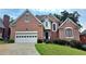Charming two-story brick home featuring a two-car garage and well-manicured lawn and shrubbery at 1255 Home Place Dr, Lawrenceville, GA 30043