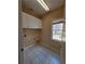 Well-lit laundry room has white cabinets and a window for natural light at 1255 Home Place Dr, Lawrenceville, GA 30043