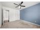 Empty bedroom with a blue accent wall, carpeted floors and ceiling fan at 1871 Stoney Chase Dr, Lawrenceville, GA 30044
