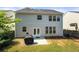 View of home's exterior and well-kept lawn from backyard with patio and grill at 1871 Stoney Chase Dr, Lawrenceville, GA 30044