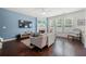 Cozy living room with fireplace, hardwood floors, large windows, and blue accent wall at 1871 Stoney Chase Dr, Lawrenceville, GA 30044