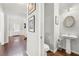 Stylish powder room with pedestal sink, oval mirror, and wood floors, located near the entry at 1871 Stoney Chase Dr, Lawrenceville, GA 30044