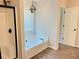 Bathroom featuring a soaking tub with black fixtures, a separate shower, and stylish wood-look floors at 3066 Gem Creek Rd, Buford, GA 30519