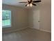 Bedroom featuring carpet floors, a ceiling fan, a window, and a white door at 3066 Gem Creek Rd, Buford, GA 30519