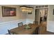 Dining room with wood table and elegant chandelier, adjacent to the open-concept kitchen at 3066 Gem Creek Rd, Buford, GA 30519