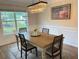 Bright dining room with wood table, decorative chandelier, and beautiful view from large window at 3066 Gem Creek Rd, Buford, GA 30519
