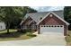 Charming brick home featuring a two-car garage, well-manicured lawn and mature trees at 3066 Gem Creek Rd, Buford, GA 30519