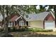 Lovely brick home showcasing a well-maintained lawn, mature trees, and a two-car garage at 3066 Gem Creek Rd, Buford, GA 30519
