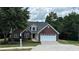 Beautiful brick home with a two-car garage, lush green lawn, and a mailbox at 3066 Gem Creek Rd, Buford, GA 30519