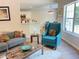 Bright living room showcasing hardwood floors, a blue accent chair, and ample natural light at 3066 Gem Creek Rd, Buford, GA 30519