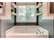 Close-up view of a luxurious bathtub with a large window, perfect for relaxing and unwinding at 40 Legend Creek Chase, Douglasville, GA 30134