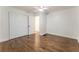 Spacious bedroom featuring wood floors, ceiling fan, and large closet with bi-fold doors at 3620 W Lawrenceville St, Duluth, GA 30096