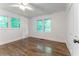 Bedroom with hardwood floors, white trim, and large windows with green view at 3620 W Lawrenceville St, Duluth, GA 30096