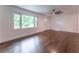 Bright living room with hardwood floors, large windows, and modern ceiling fan at 3620 W Lawrenceville St, Duluth, GA 30096