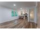 Bright living room featuring wood floors, a kitchen island with seating, and modern recessed lighting at 3620 W Lawrenceville St, Duluth, GA 30096