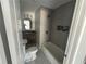 Bathroom featuring tile flooring, a tub shower with a niche, and dark wood vanity at 4610 Wilson James Sw Rd, Atlanta, GA 30331