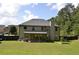 Expansive backyard features a lush lawn, mature trees, and a covered patio at 5896 Cliftondale Dr, Atlanta, GA 30349