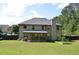 Large backyard features an expansive lawn, mature trees, and a covered patio at 5896 Cliftondale Dr, Atlanta, GA 30349