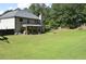 Large backyard with a garden bed, covered patio, and tree line at 5896 Cliftondale Dr, Atlanta, GA 30349