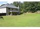 Sprawling backyard features a lush lawn, mature trees, and a partially covered patio at 5896 Cliftondale Dr, Atlanta, GA 30349