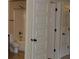 Neutral bathroom featuring a toilet, tub-shower, and three white doors with black hardware at 5896 Cliftondale Dr, Atlanta, GA 30349