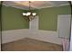 This dining room features traditional wainscoting and a coffered ceiling with an elegant chandelier at 5896 Cliftondale Dr, Atlanta, GA 30349