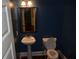 Small powder room features blue walls, pedestal sink, wood-framed mirror and modern lighting at 5896 Cliftondale Dr, Atlanta, GA 30349