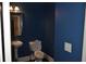 Small powder room features blue walls, pedestal sink, wood-framed mirror and modern lighting at 5896 Cliftondale Dr, Atlanta, GA 30349