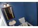Small powder room features blue walls, pedestal sink, wood-framed mirror and modern lighting at 5896 Cliftondale Dr, Atlanta, GA 30349