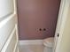 Small powder room with mauve wall and toilet at 5896 Cliftondale Dr, Atlanta, GA 30349