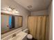 Bathroom with gold trimmed mirror, vanity, toilet, and shower with gold shower curtain at 1297 Tree Creek Ct, Clarkston, GA 30021