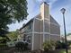 View of two-story siding of townhome with a chimney extending from the roof, surrounded by trees at 1297 Tree Creek Ct, Clarkston, GA 30021