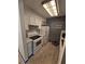 Galley kitchen featuring white appliances, cabinets, and a black brick accent wall at 1297 Tree Creek Ct, Clarkston, GA 30021