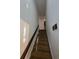 Carpeted staircase with a wooden handrail and bright, neutral walls at 1297 Tree Creek Ct, Clarkston, GA 30021