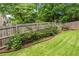 Fenced backyard with green grass and landscape beds with metal edging, perfect for outdoor activities at 2864 Wyndcliff Ct, Marietta, GA 30066