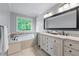 Well-lit bathroom with double sinks, soaking tub, and large window view at 2864 Wyndcliff Ct, Marietta, GA 30066