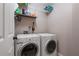 Functional laundry room with a washer, dryer, and overhead shelving for organized storage at 2864 Wyndcliff Ct, Marietta, GA 30066