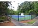 Well-maintained community tennis court with green and blue playing surface surrounded by lush trees at 2864 Wyndcliff Ct, Marietta, GA 30066