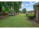 Spacious backyard features lush green lawn, mature trees, a storage shed, and partial fencing at 4212 Worth Nw St, Acworth, GA 30101