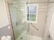 Walk-in shower with tiled walls, glass door, and window with patterned privacy film at 4212 Worth Nw St, Acworth, GA 30101
