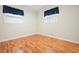 Bedroom showcasing hardwood flooring and two windows with blinds and blue curtains at 4212 Worth Nw St, Acworth, GA 30101