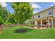 Spacious backyard featuring a lush green lawn, landscaping, and covered outdoor living space at 4972 Park Vale Dr, Sugar Hill, GA 30518