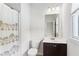Bright bathroom with a shower featuring an elephant-themed curtain, toilet, vanity, mirror, and window at 4972 Park Vale Dr, Sugar Hill, GA 30518
